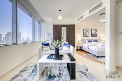 a living room with two beds and a table at Best Value Modern 1BR with Pool & Stunning Views by Deluxe Holiday Homes in Dubai