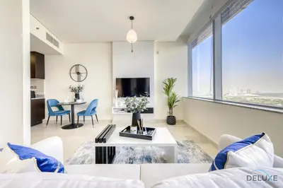 a living room with a couch and a table at Best Value Modern 1BR with Pool & Stunning Views by Deluxe Holiday Homes in Dubai