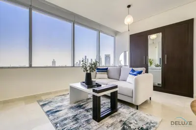 a living room with a couch and a table at Best Value Modern 1BR with Pool & Stunning Views by Deluxe Holiday Homes in Dubai