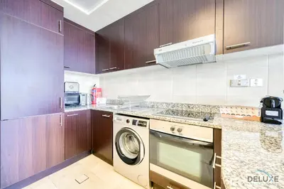 a kitchen with a washer and a dishwasher at Best Value Modern 1BR with Pool & Stunning Views by Deluxe Holiday Homes in Dubai