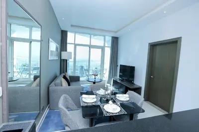 a living room with a couch and a table and chairs at DAMAC MAISON PRIVE in Dubai