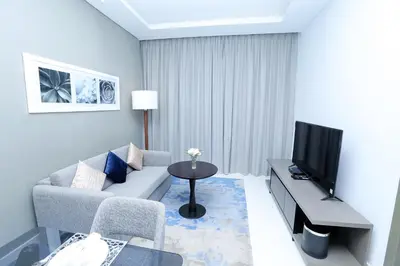 a living room with a couch and a tv at DAMAC MAISON PRIVE in Dubai