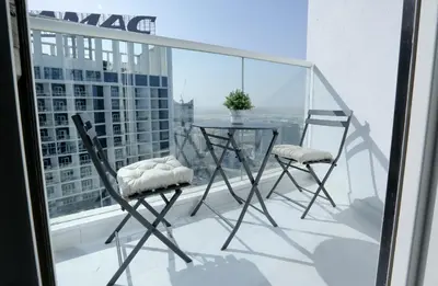 a table and two chairs on a balcony with a view at DAMAC MAISON PRIVE in Dubai