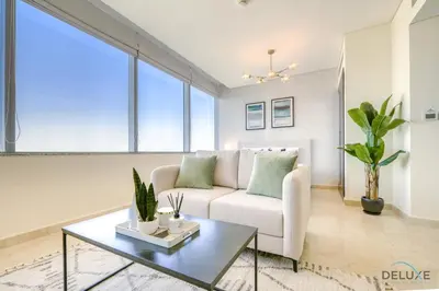 a living room with a couch and a table at Great Deal Cozy 1BR with Pool & City Views by Deluxe Holiday Homes in Dubai