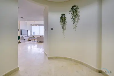 a hallway with a white wall with plants on it at Great Deal Cozy 1BR with Pool & City Views by Deluxe Holiday Homes in Dubai