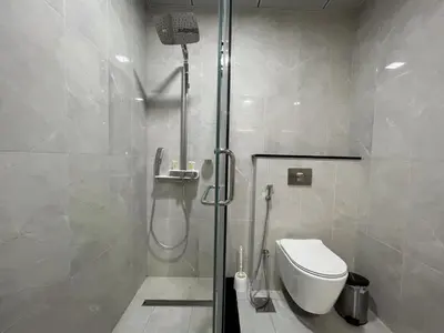 a bathroom with a shower and a toilet at Penrose Place Dubai JVC in Dubai