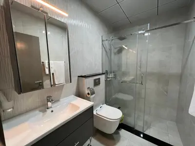 a bathroom with a sink and a shower and a toilet at Penrose Place Dubai JVC in Dubai