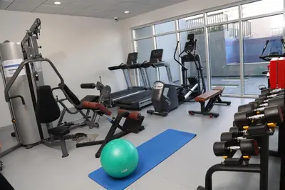 a gym with exercise equipment and a ball in the middle at Penrose Place Dubai JVC in Dubai