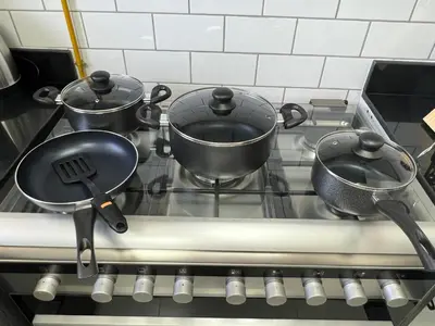 two pots and pans on a stove in a kitchen at Penrose Place Dubai JVC in Dubai