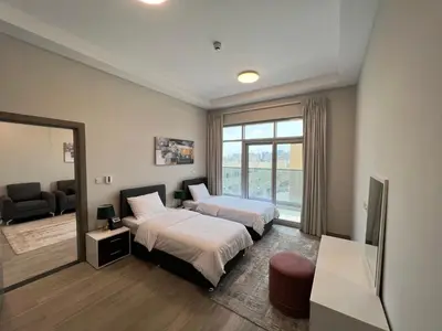 a hotel room with two beds and a window at Penrose Place Dubai JVC in Dubai