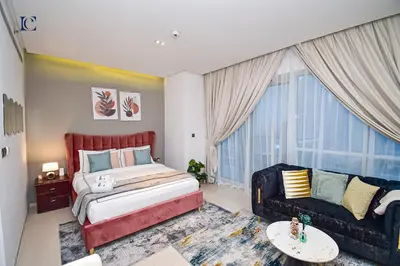 a bedroom with a large bed and a couch at Luxury Escapes - Modern studio in West Avenue Dubai Marina in Dubai