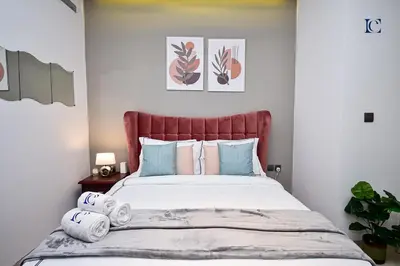 a bedroom with a large bed with blue and pink pillows at Luxury Escapes - Modern studio in West Avenue Dubai Marina in Dubai