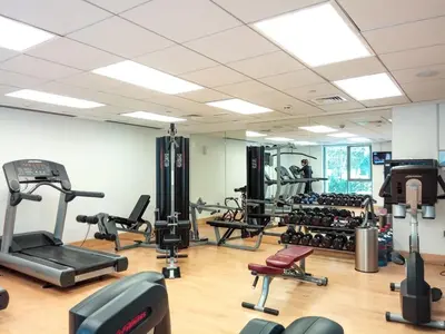 a gym with several treadmills and exercise bikes at Silkhaus lovely studio with Downtown view in Boulevard central in Dubai