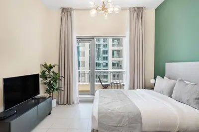 a bedroom with a bed and a flat screen tv at Silkhaus lovely studio with Downtown view in Boulevard central in Dubai