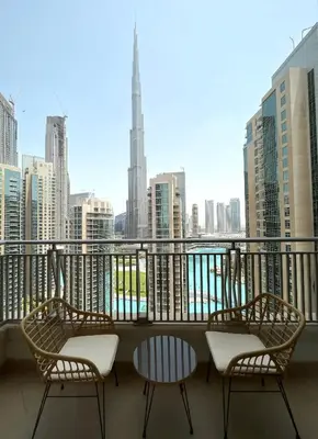 a balcony with chairs and a view of a city at Silkhaus with full Burj Khalifa & fountain view 1BDR in Downtown in Dubai
