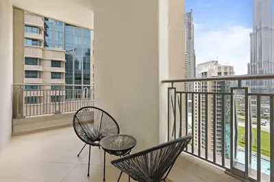 a balcony with two chairs and a view of the city at Silkhaus with full Burj Khalifa & fountain view 1BDR in Downtown in Dubai