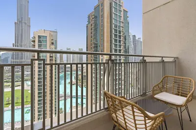 a balcony with two chairs and a view of the city at Silkhaus with full Burj Khalifa & fountain view 1BDR in Downtown in Dubai