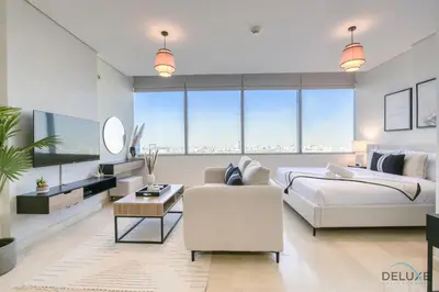 a bedroom with a king sized bed and a couch at Opulent Studio at Sky Gardens DIFC by Deluxe Holiday Homes in Dubai