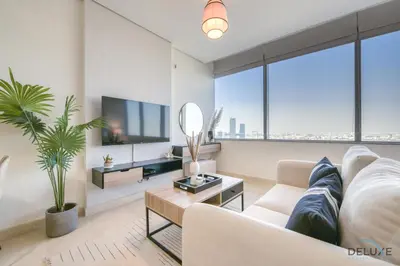 a living room with a white couch and a tv at Opulent Studio at Sky Gardens DIFC by Deluxe Holiday Homes in Dubai