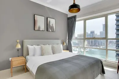 a bedroom with a large bed and a large window at Marina Quays West, Dubai Marina - Mint Stay in Dubai