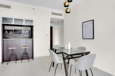 a dining room with a glass table and white chairs at Marina Quays West, Dubai Marina - Mint Stay in Dubai
