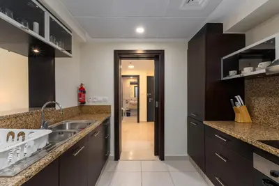 a kitchen with black cabinets and a sink at Marina Quays West, Dubai Marina - Mint Stay in Dubai
