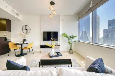 a living room with a couch and a table at Affordable Luxury Modern 1BR with Pool & Balcony by Deluxe Holiday Homes in Dubai
