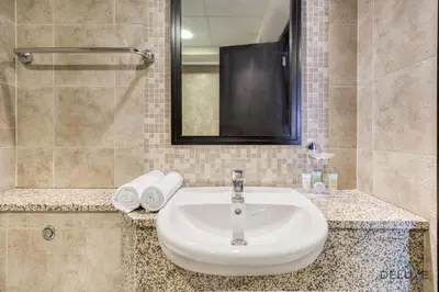 a bathroom with a sink and a mirror at Affordable Luxury Modern 1BR with Pool & Balcony by Deluxe Holiday Homes in Dubai