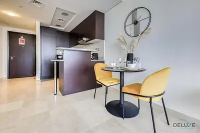 a dining room with a table and two chairs at Affordable Luxury Modern 1BR with Pool & Balcony by Deluxe Holiday Homes in Dubai