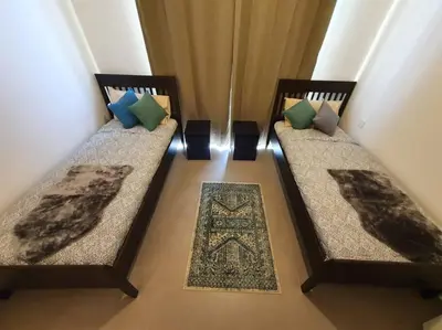 two beds with pillows and a rug in a room at 2 Bedroom Apartment Available For Short Term Stay in Dubai