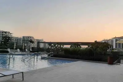 a swimming pool with a view of the water and buildings at 2 Bedroom Apartment Available For Short Term Stay in Dubai