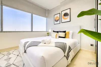 a white bedroom with a large white bed with pillows at Refreshing Studio at Sky Gardens DIFC by Deluxe Holiday Homes in Dubai