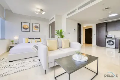 a living room with a white bed and a white couch at Refreshing Studio at Sky Gardens DIFC by Deluxe Holiday Homes in Dubai