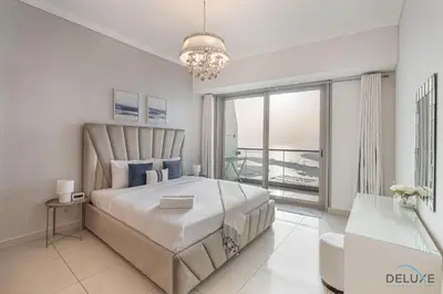 a bedroom with a large bed and a balcony at Scenic 1BR at Ocean Heights Dubai Marina by Deluxe Holiday Homes in Dubai