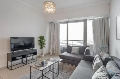 a living room with a couch and a tv at Scenic 1BR at Ocean Heights Dubai Marina by Deluxe Holiday Homes in Dubai