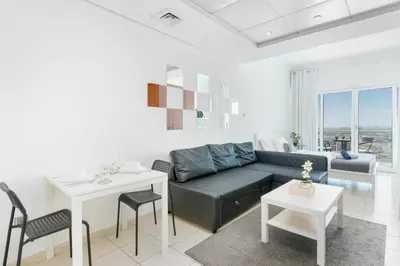a living room with a couch and a table at White Sage - Luxurious Studio in JLT With City Skyline View in Dubai