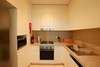 a kitchen with white cabinets and a stove top oven at Elegant Apartment with Direct access to Dubai Mall in Dubai