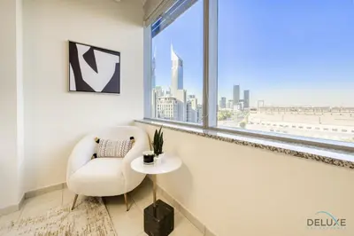 a white chair and a table in a room with a window at Jubilant 1BR at Sky Gardens DIFC by Deluxe Holiday Homes in Dubai