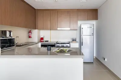 a kitchen with wooden cabinets and a white refrigerator at GuestReady - Luxury l Sea Views Oasis in Dubai