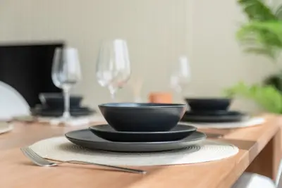 a wooden table with plates and wine glasses at GuestReady - Luxury l Sea Views Oasis in Dubai