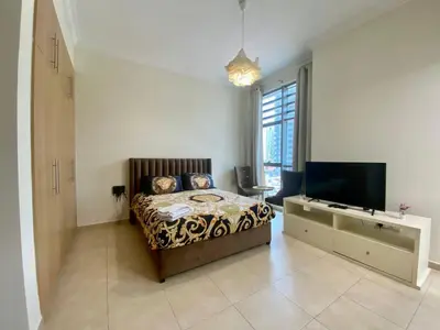 a bedroom with a bed and a flat screen tv at Cosy Studio in Marina in Dubai