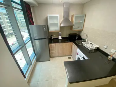 a kitchen with a stainless steel refrigerator and a sink at Cosy Studio in Marina in Dubai