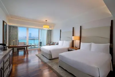 a hotel room with two beds and a television at Waldorf Astoria Dubai Palm Jumeirah in Dubai