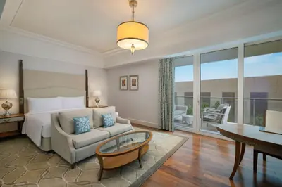 a bedroom with a bed and a couch and a table at Waldorf Astoria Dubai Palm Jumeirah in Dubai