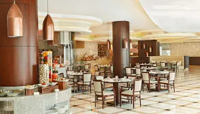 a restaurant with tables and chairs in a room at Waldorf Astoria Dubai Palm Jumeirah in Dubai