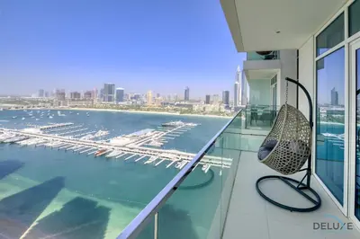 a balcony with a chair and a view of an airport at Exotic 2BR at Sunrise Bay Tower 1 Emaar Beachfront Dubai Marina by Deluxe Holiday Homes in Dubai