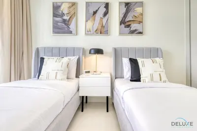 two beds sitting next to each other in a bedroom at Exotic 2BR at Sunrise Bay Tower 1 Emaar Beachfront Dubai Marina by Deluxe Holiday Homes in Dubai