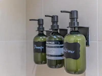 a group of three bottles of green liquid on a wall at Glamorous Apartment Facing Burj Khalifa in Dubai