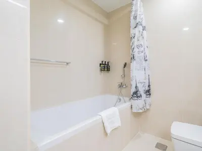 a white bathroom with a tub and a toilet at Glamorous Apartment Facing Burj Khalifa in Dubai