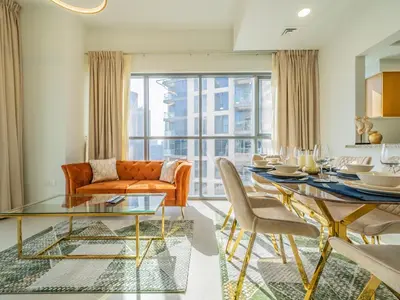 a living room with a glass table and a couch at Glamorous Apartment Facing Burj Khalifa in Dubai